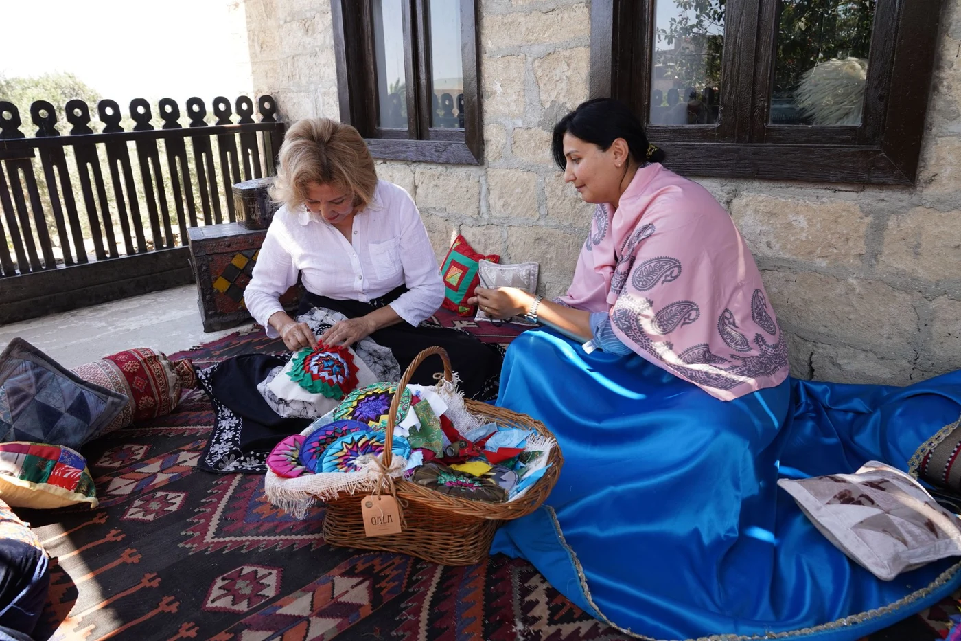 Two women spending time together working with colourful textile crafts.