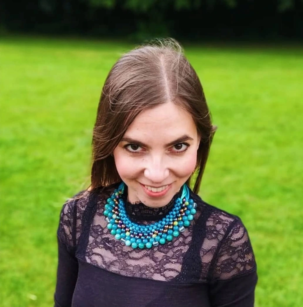Ania outdoors, wearing the turquoise beaded necklace her friend made for her.