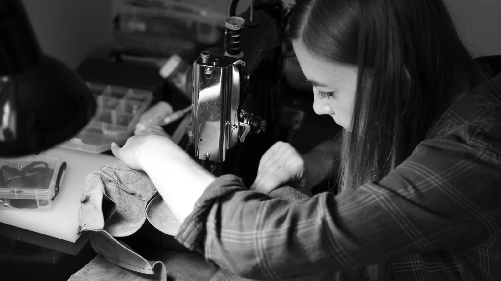 Ania sewing leather at a sewing machine while working on a handmade project.